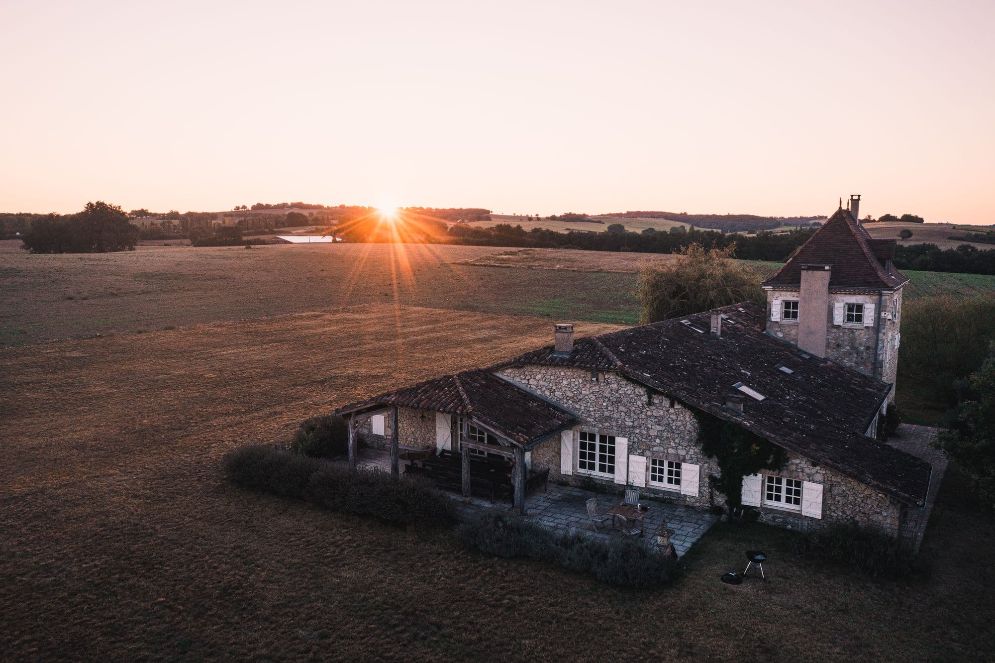The house from the air at sunset, its land running away in every direction