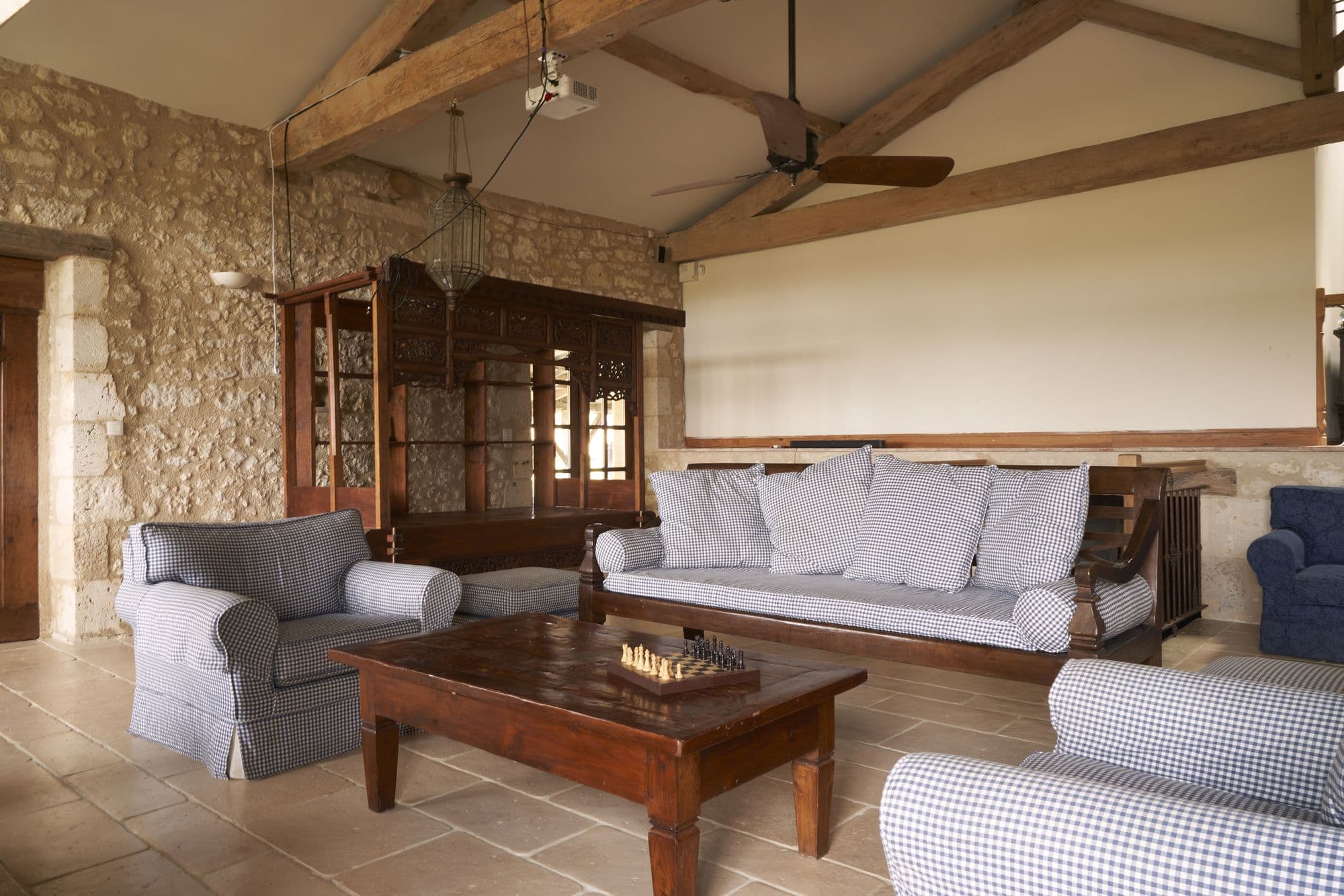The living room under open timber trusses with a mezzanine above