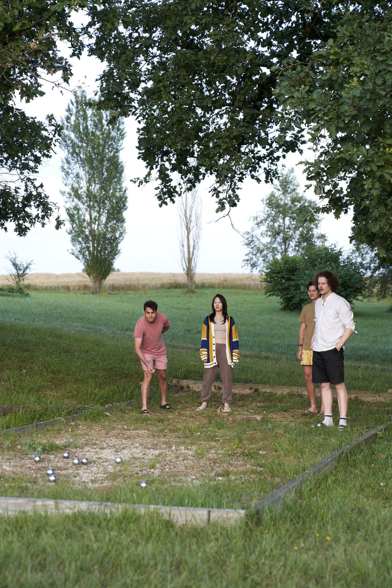 Guests playing pétanque on the court beside the house