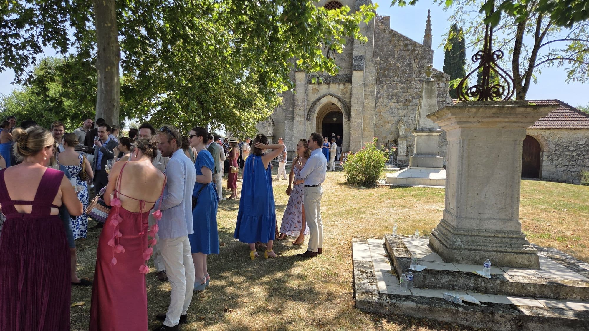 Wedding guests gathered outside the stone church after the ceremony